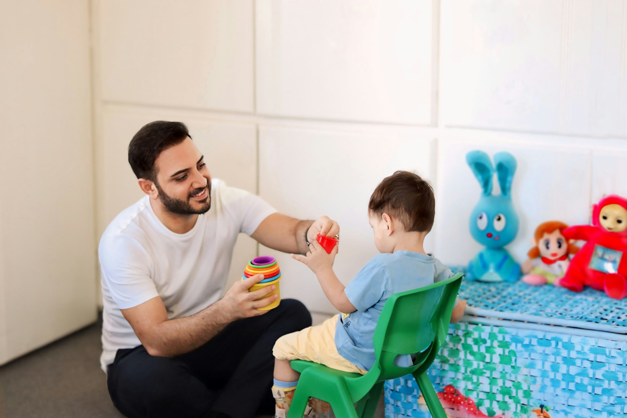 Therapist supporting a child through a play-based communication activity