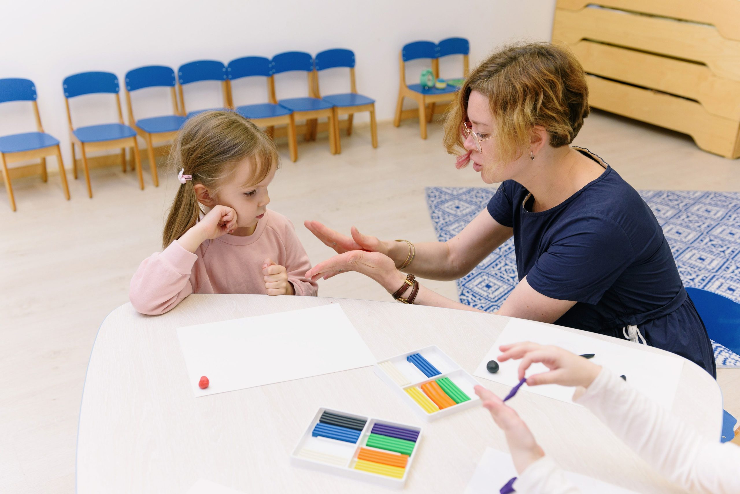 Therapist supporting a child with social communication and learning activities